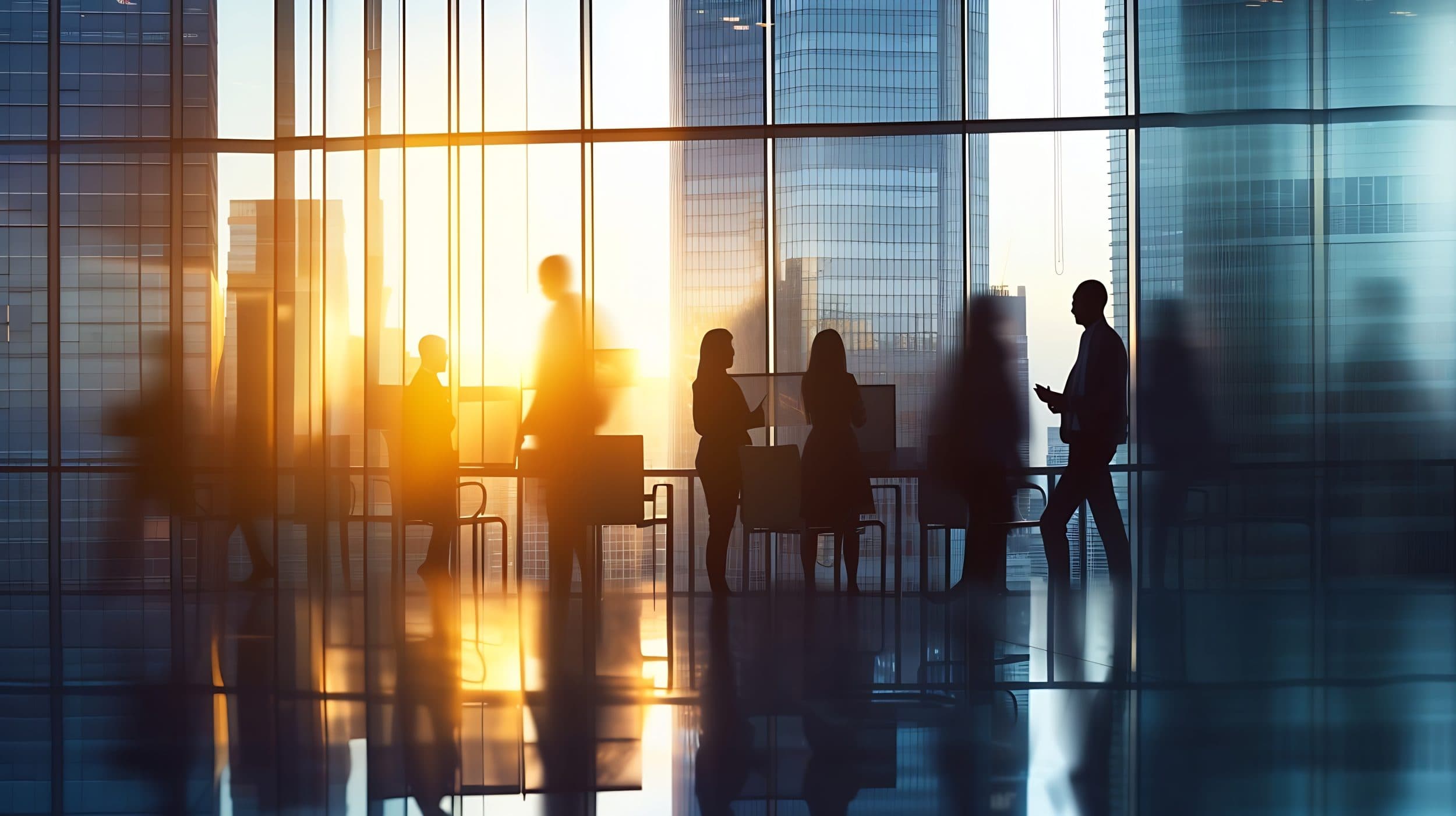 Silhouetted professionals in a modern office overlooking city skyscrapers during a golden sunset.